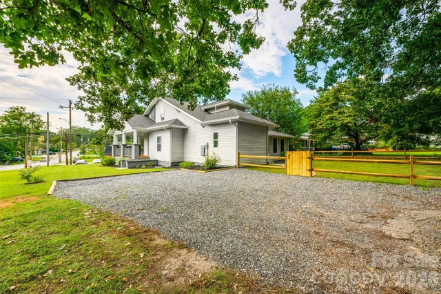 a view of a house with a big yard and large trees