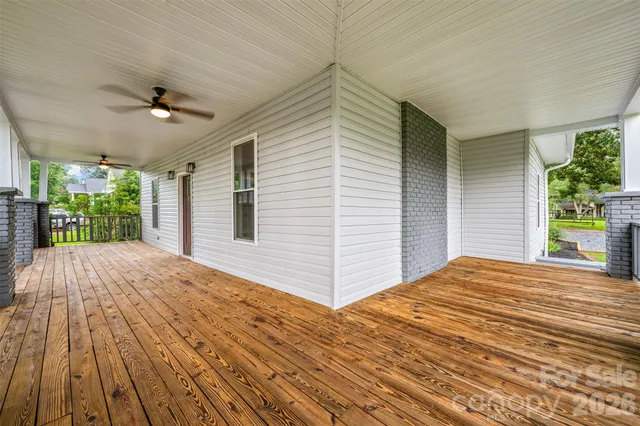 a view of a livingroom with wooden floor and a ceiling fan