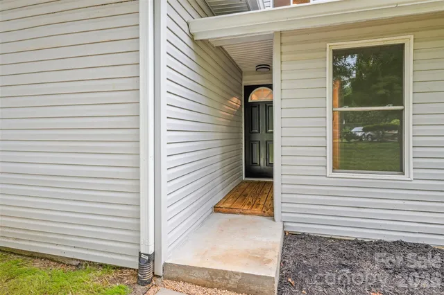 a view of a porch with a door and wooden floor