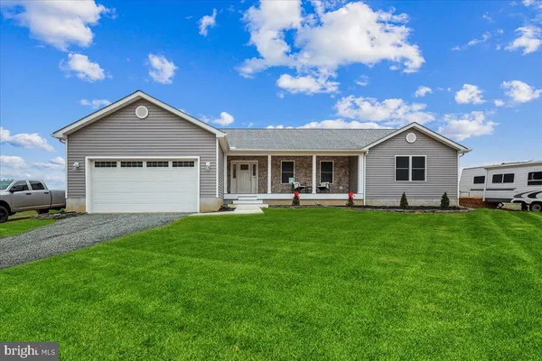 a front view of a house with a garden and yard