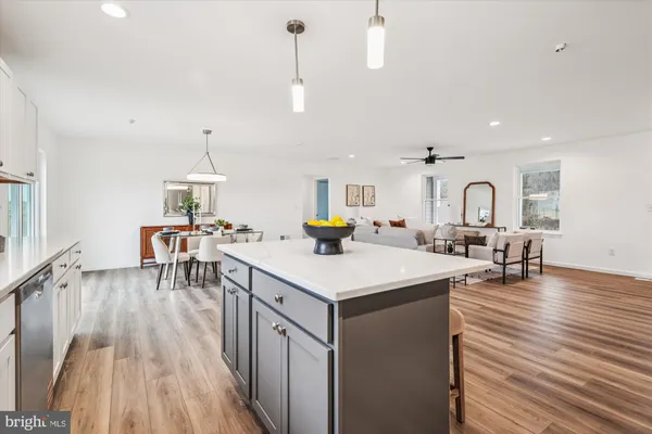 a kitchen with refrigerator a stove a sink dishwasher and white cabinets with wooden floor