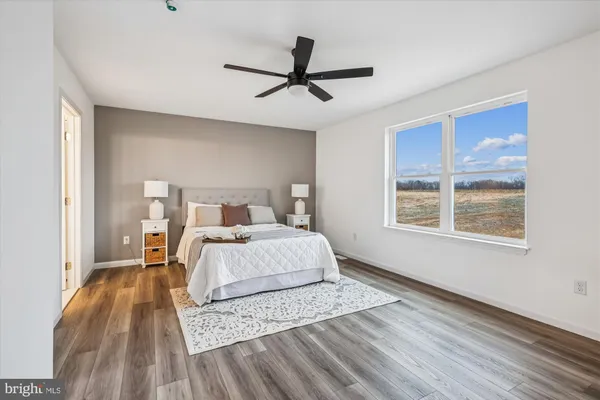 a bedroom with a large bed a chandelier and a window