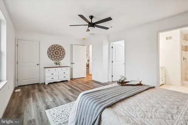 an empty room with wooden floor and ceiling fan