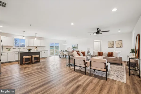 a living room with furniture and a view of kitchen