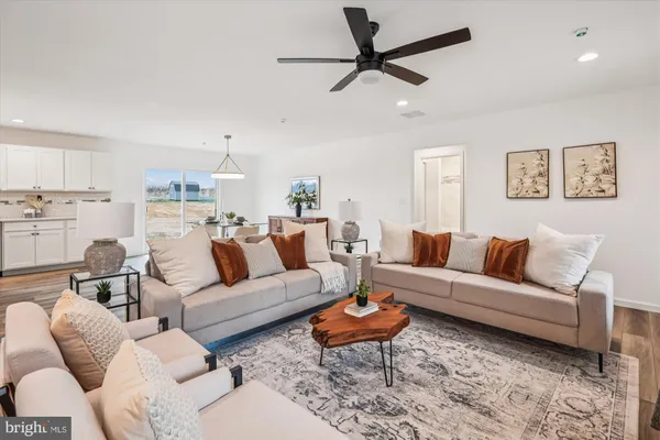 a living room with furniture two window and a chandelier