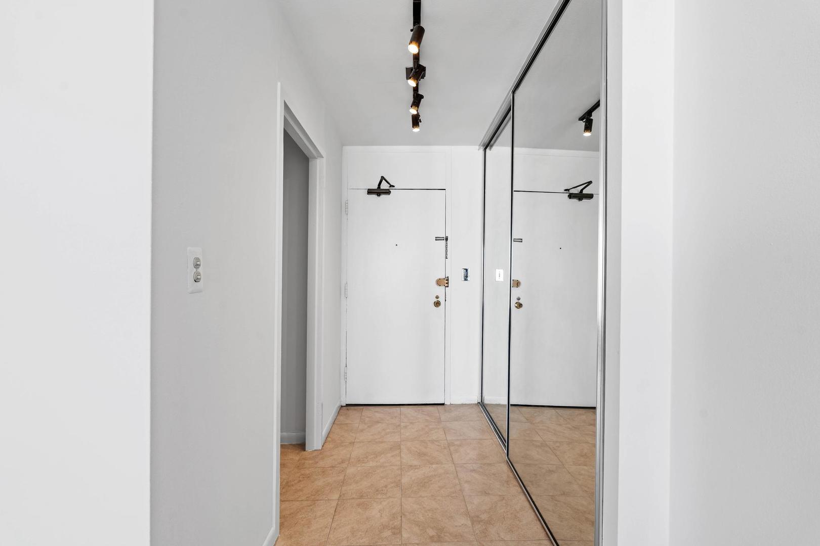 5455 North Sheridan Road, Unit 3611 Chicago, IL 60640 - Photo 12 of 18 a view of a hallway with wooden floor and a bathroom