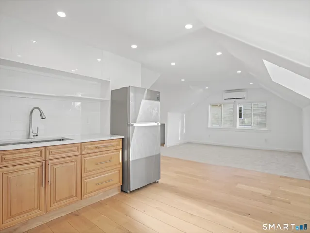 a kitchen with white cabinets and refrigerator