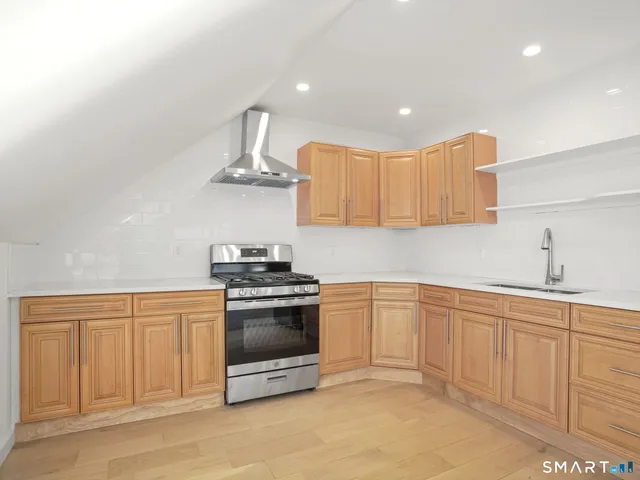 a kitchen with stainless steel appliances granite countertop a sink and a stove