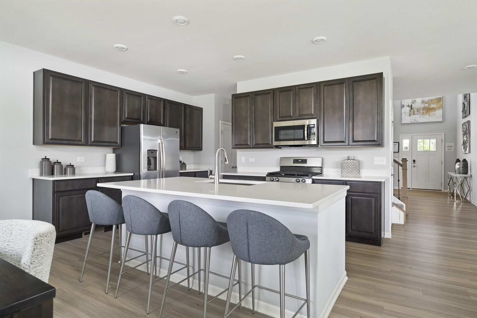 3664 Edelweiss Road Elgin, IL 60124 - Photo 12 of 31 a kitchen with stainless steel appliances granite countertop a stove top oven a sink dishwasher a dining table and chairs with wooden floor