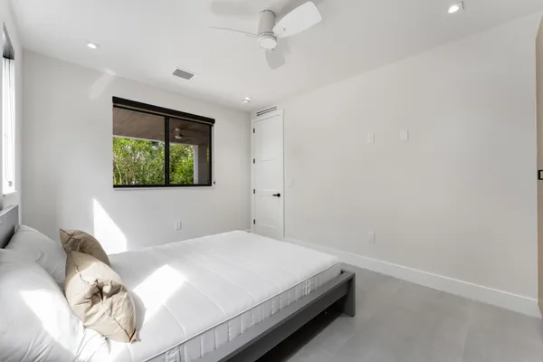 a spacious bedroom with a bed and a window