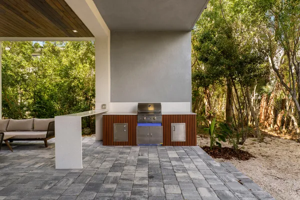 a view of a backyard with open kitchen