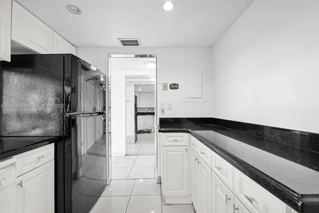 a kitchen with a refrigerator and a stove top oven