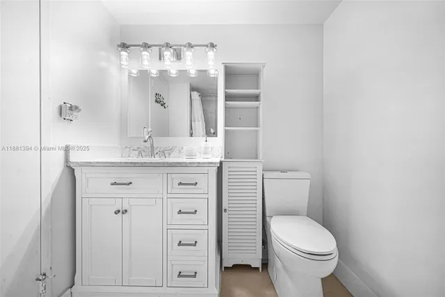 a bathroom with a sink a toilet and large mirror