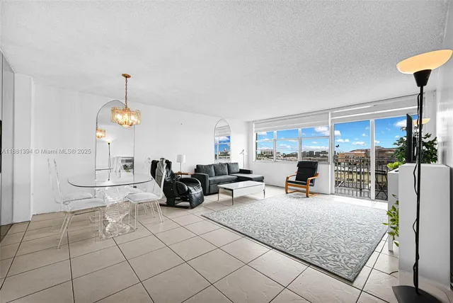 a living room with patio furniture and a chandelier