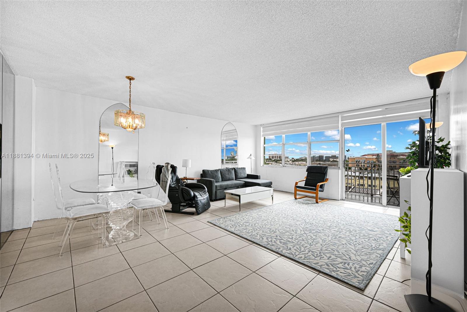 2100 Sans Souci Boulevard, Unit A509 North Miami, FL 33181 - Photo 7 of 44 a living room with patio furniture and a chandelier