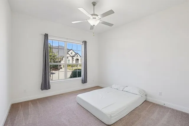 a spacious bedroom with a bed and a ceiling fan