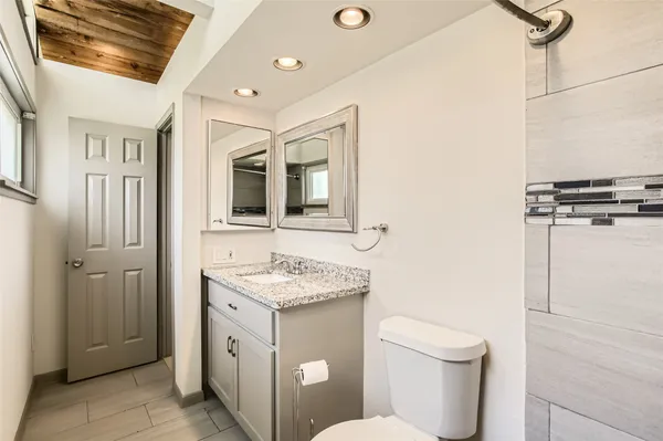 a bathroom with a toilet sink and mirror