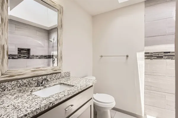 a bathroom with a granite countertop sink and a mirror