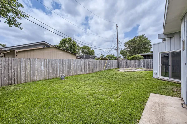 a view of a backyard with potted plants and wooden fence