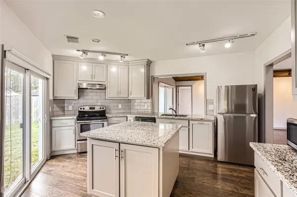 a kitchen with stainless steel appliances granite countertop a refrigerator stove microwave and sink