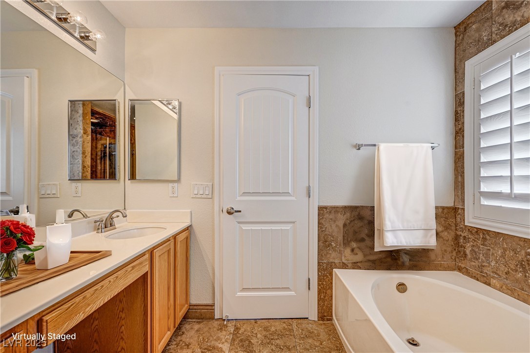 991 Ridge Path Avenue Henderson, NV 89015 - Photo 12 of 24 Full bath with double vanity, a sink, and a bath