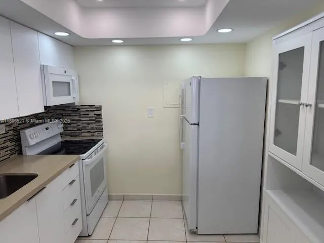 a kitchen with a refrigerator and a stove top oven
