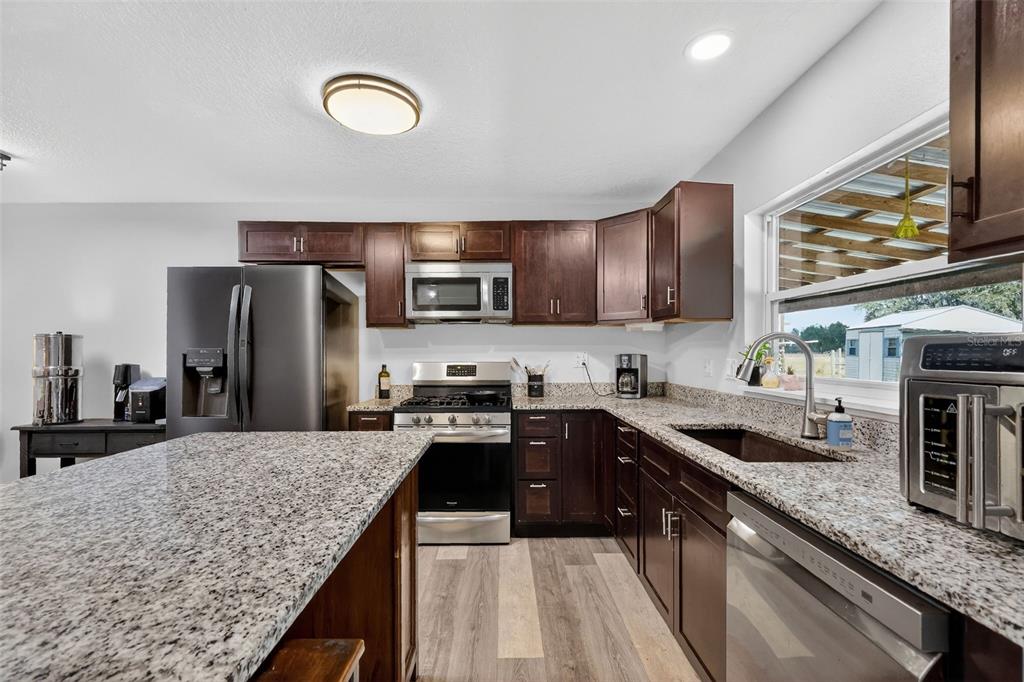 4533 Southwest 37th Terrace Bushnell, FL 33513 - Photo 16 of 58 a kitchen with granite countertop a sink a counter space appliances and cabinets