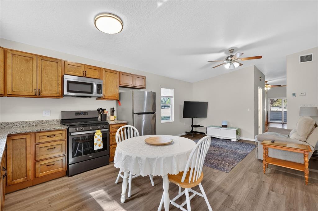 4533 Southwest 37th Terrace Bushnell, FL 33513 - Photo 33 of 58 a living room with stainless steel appliances furniture a fireplace and a flat screen tv