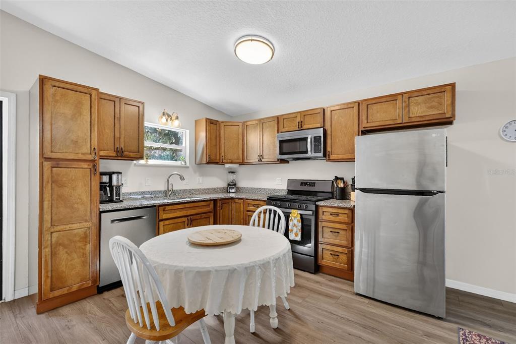 4533 Southwest 37th Terrace Bushnell, FL 33513 - Photo 36 of 58 a kitchen with stainless steel appliances granite countertop a refrigerator stove microwave and sink