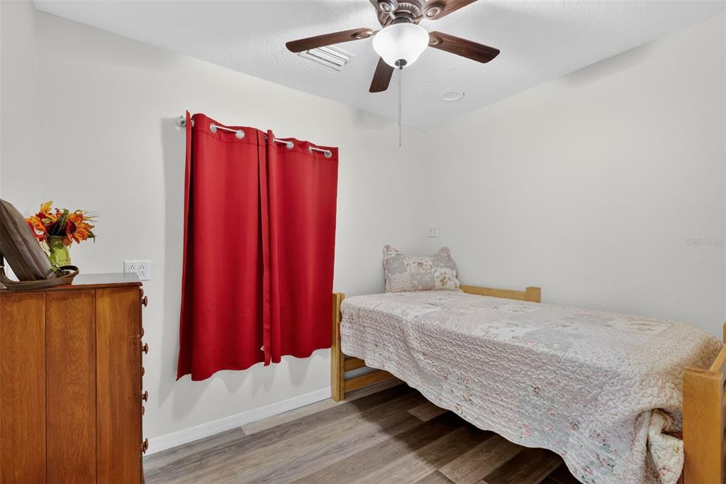 4533 Southwest 37th Terrace Bushnell, FL 33513 - Photo 38 of 58 a bedroom with a bed and a chandelier