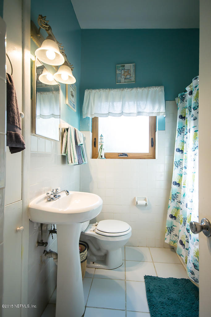 10504 Rutgers Road Jacksonville, FL 32218 - Photo 13 of 32 a bathroom with a sink toilet and mirror