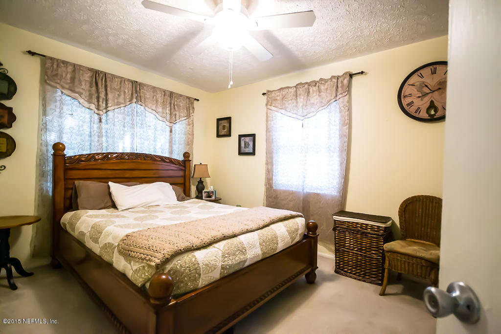 10504 Rutgers Road Jacksonville, FL 32218 - Photo 14 of 32 a bedroom with a bed and a chandelier