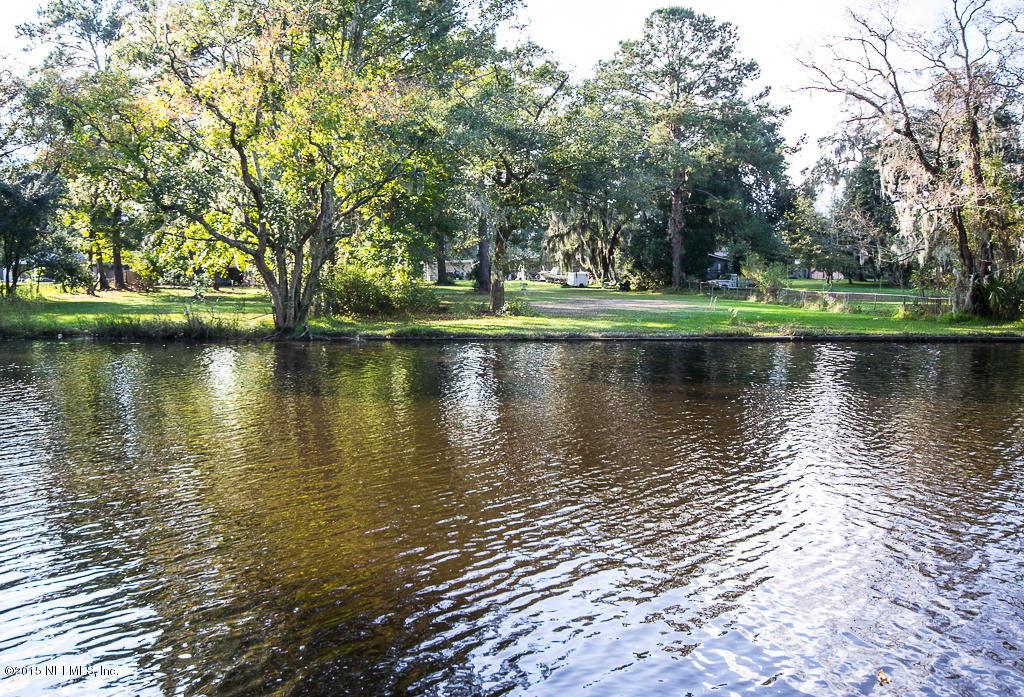 10504 Rutgers Road Jacksonville, FL 32218 - Photo 21 of 32 a view of a lake with a yard and large trees