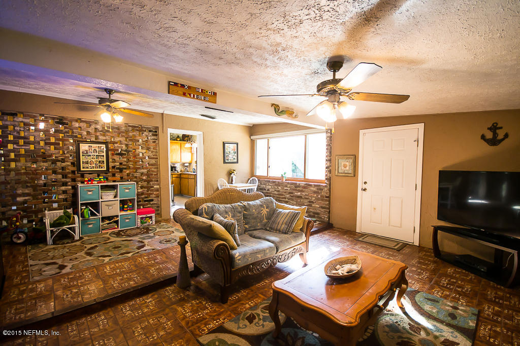 10504 Rutgers Road Jacksonville, FL 32218 - Photo 6 of 32 a living room with furniture a flat screen tv and a table