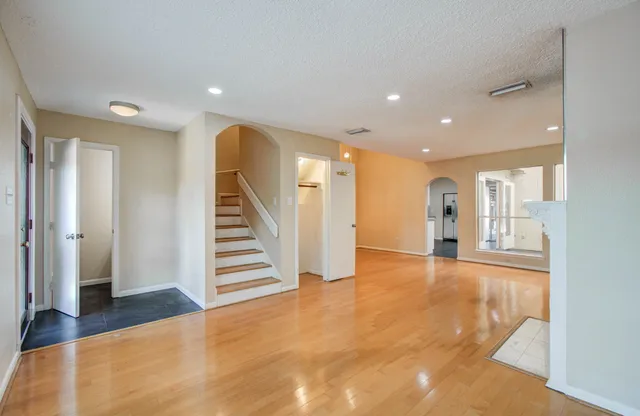 a view of a hallway with entryway and wooden floor