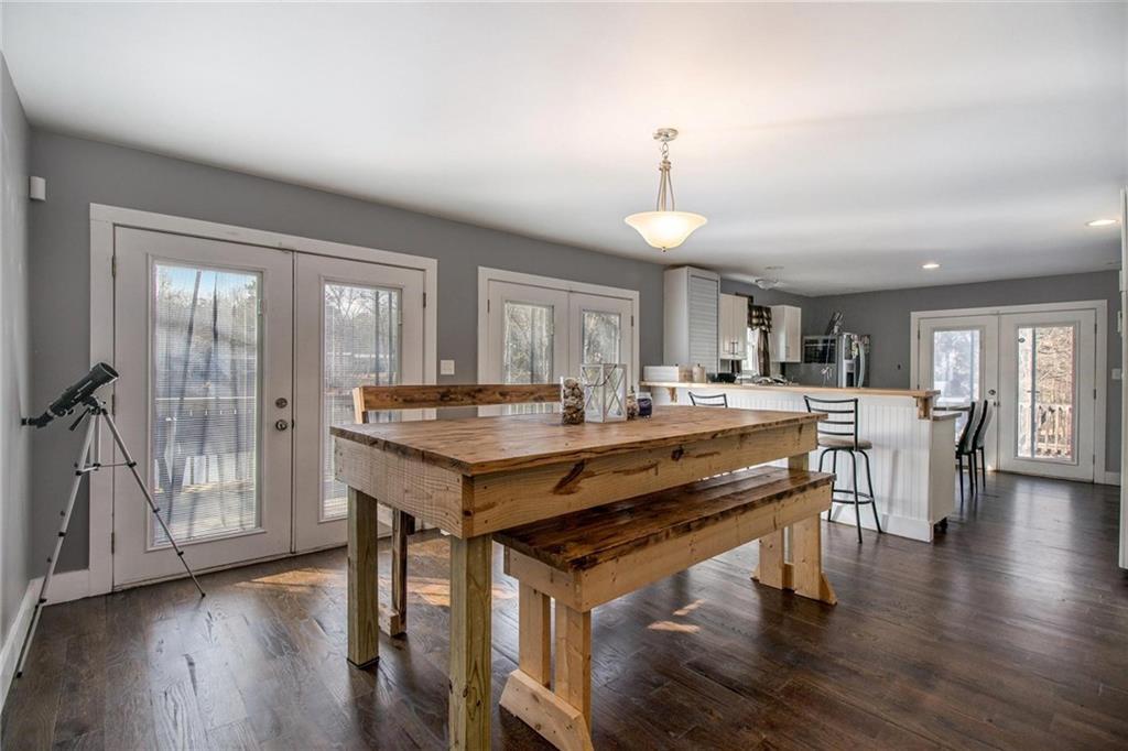 1585 Golden Pond Road Buchanan, GA 30113 - Photo 18 of 30 a room with stainless steel appliances kitchen island granite countertop a stove a refrigerator a sink a dining table and chairs with wooden floor