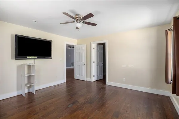 an empty room with wooden floor and windows