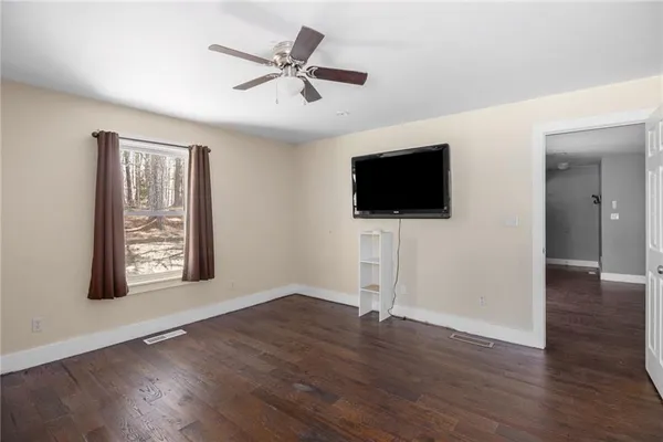 a view of a livingroom with wooden floor and a flat screen tv