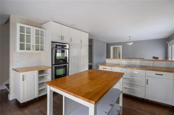 a kitchen with kitchen island a counter top space cabinets and stainless steel appliances