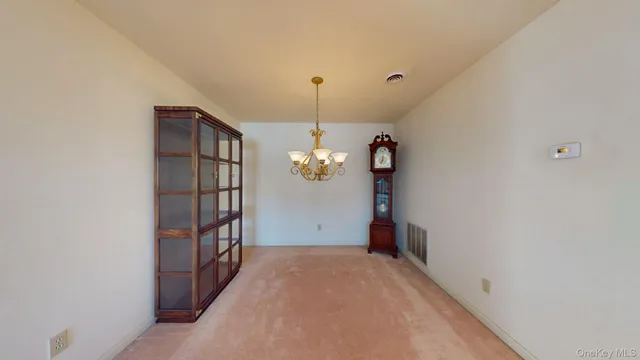 a view of a hallway to a livingroom with furniture