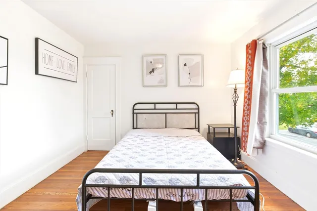 a large bedroom with a bed and wooden floor