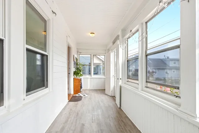 a view of a big room with wooden floor and windows
