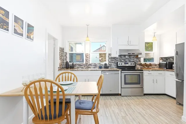 a kitchen with stainless steel appliances granite countertop a white cabinets and a stove