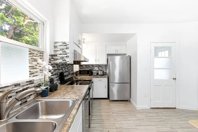 a kitchen with a sink a refrigerator and window
