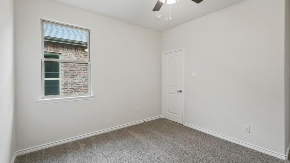4162 Waldron Trail Forney, TX 75126 - Photo 22 of 29 Spacious room featuring neutral paint, gray carpet, a ceiling fan, white trim, and a window with brick exterior visibility