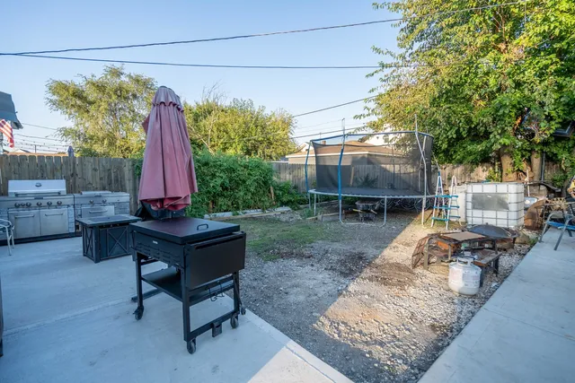 a view of a backyard with a sitting area and a wooden fence