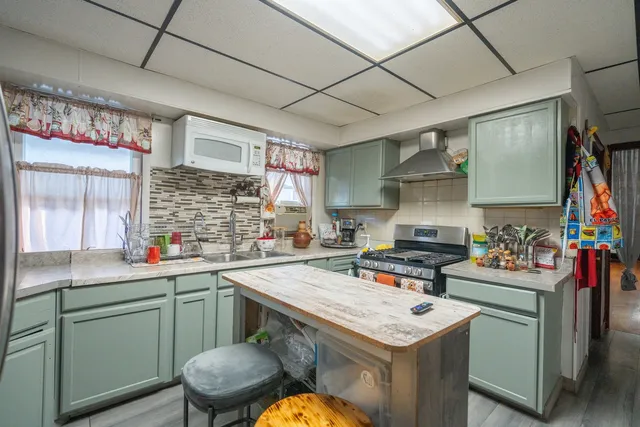 a kitchen with a sink a stove and cabinets