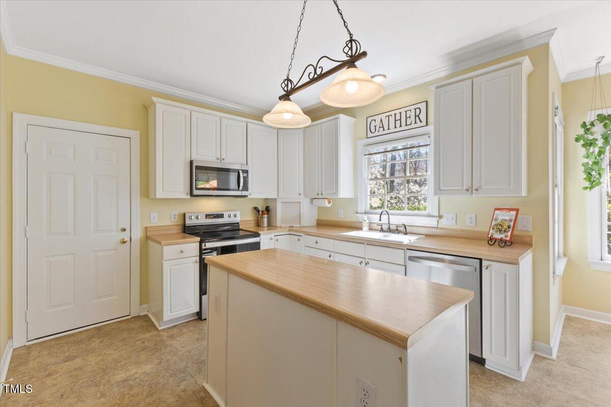 4617 Wee Burn Trail Raleigh, NC 27612 - Photo 26 of 70 a kitchen with stainless steel appliances granite countertop a sink a stove a refrigerator cabinets and a window