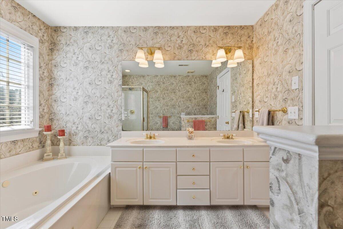 4617 Wee Burn Trail Raleigh, NC 27612 - Photo 39 of 70 a bathroom with a double vanity sink mirror and bathtub