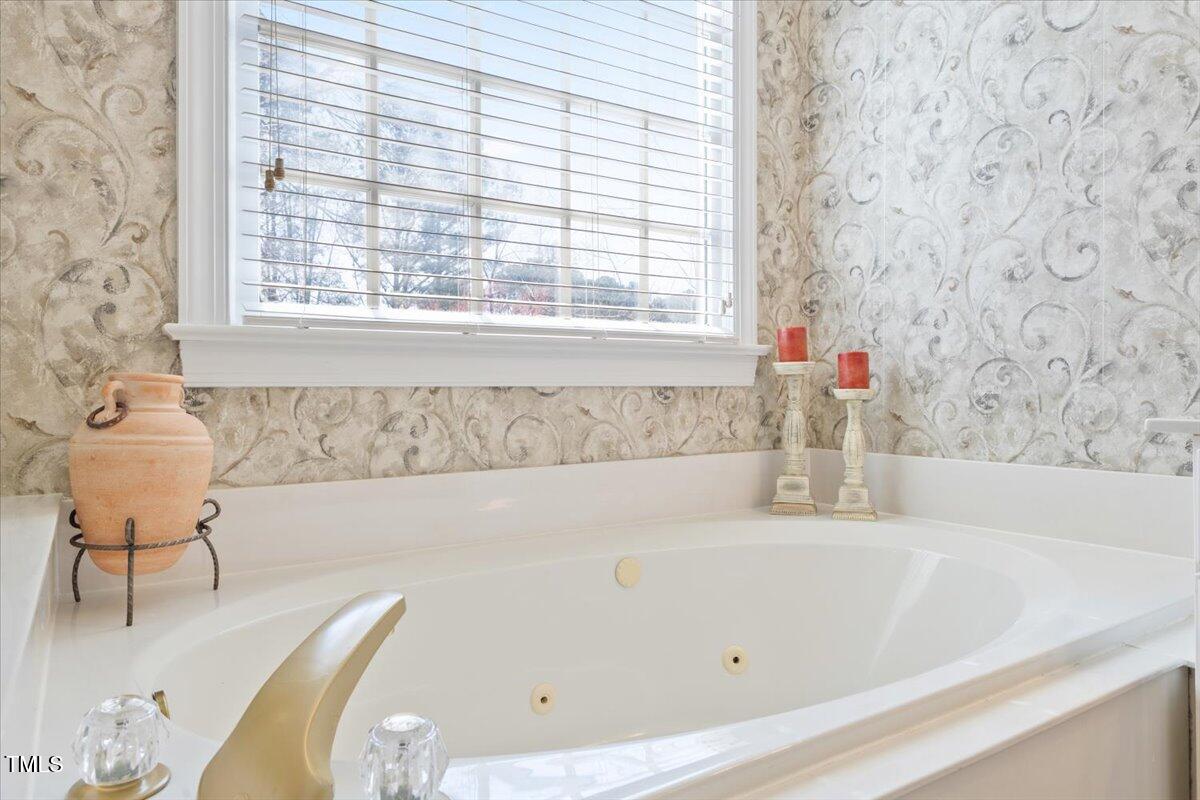 4617 Wee Burn Trail Raleigh, NC 27612 - Photo 41 of 70 a bathroom with a bathtub and a window